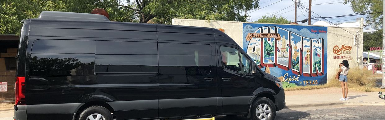 Black Sprinter van parked in front of the Greetings from Austin mural — Sprinter Rentals Austin Texas van rental