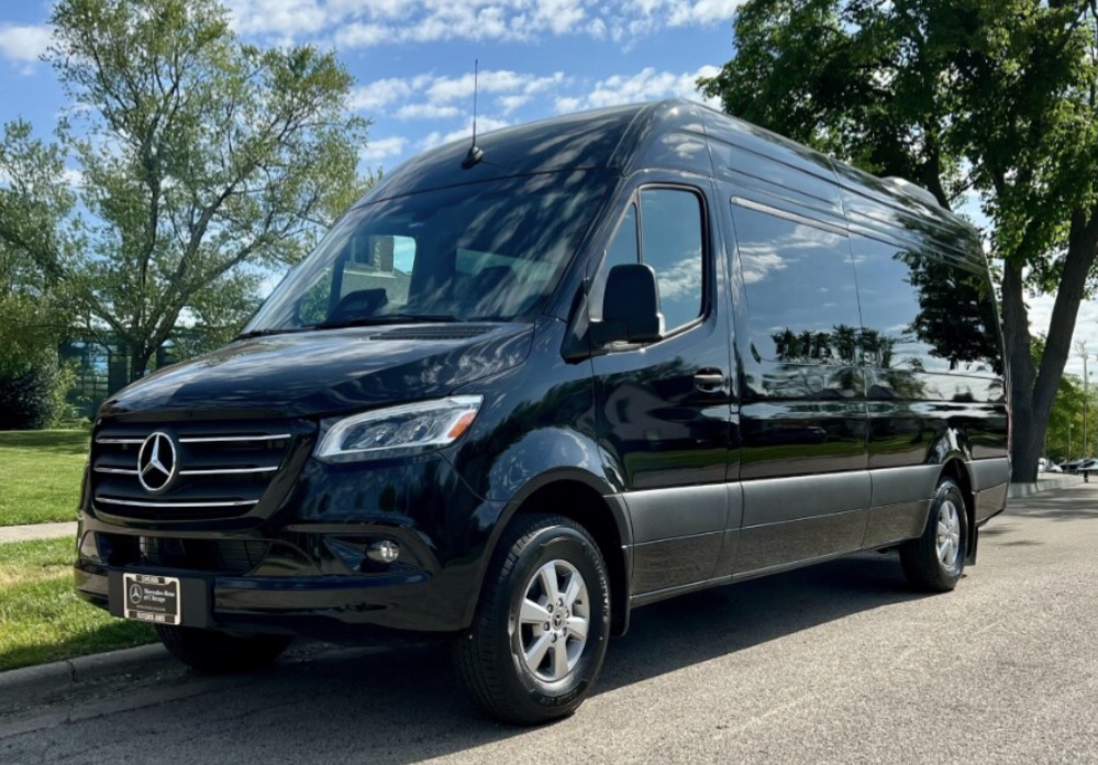 Black Mercedes-Benz Sprinter passenger van parked on a tree-lined street — Sprinter Rentals Chicago van rental