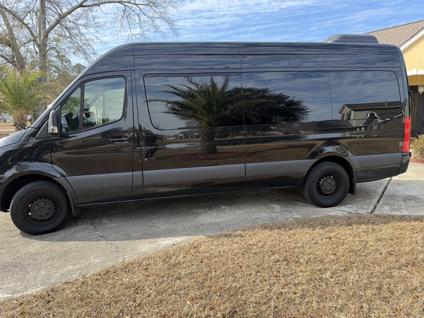 Black Mercedes-Benz Sprinter passenger van side profile for group rentals in St. Louis, MO