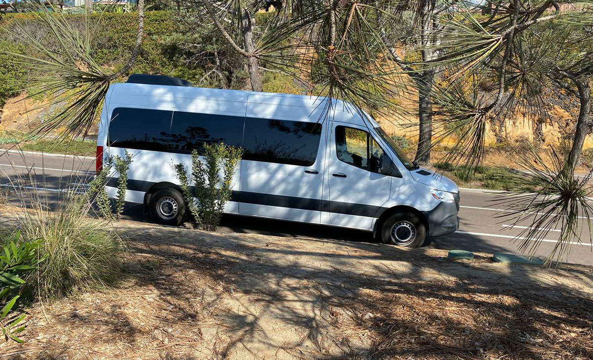 "A 15-passenger Sprinter van driving safely on a school trip in 2025"
